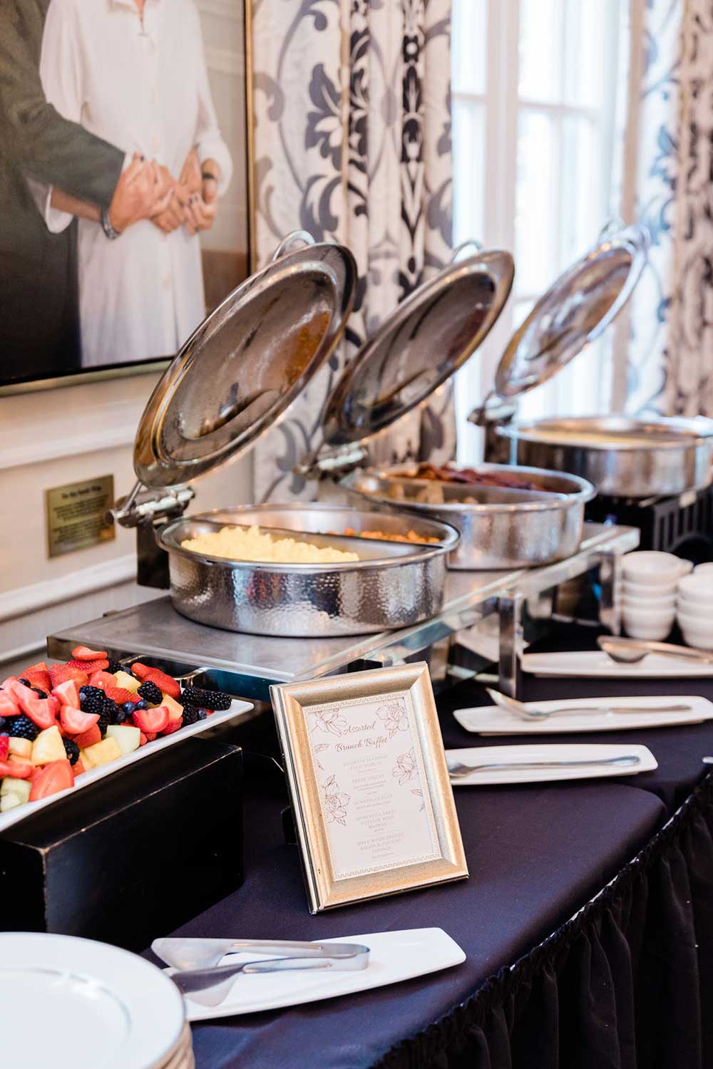 A buffet table with various food items and a menu